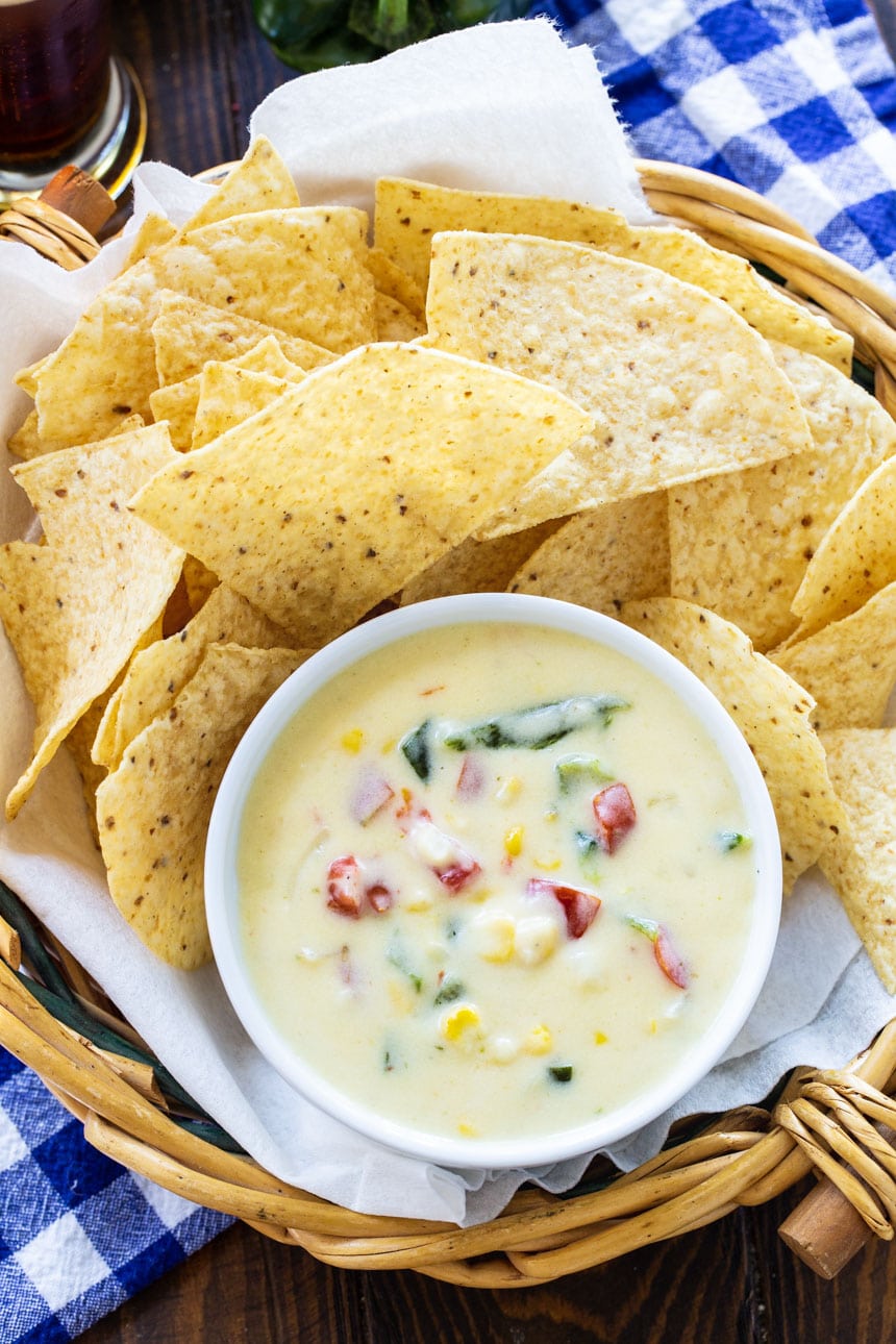 Queso in a small ramekin surrounded by tortilla chips.