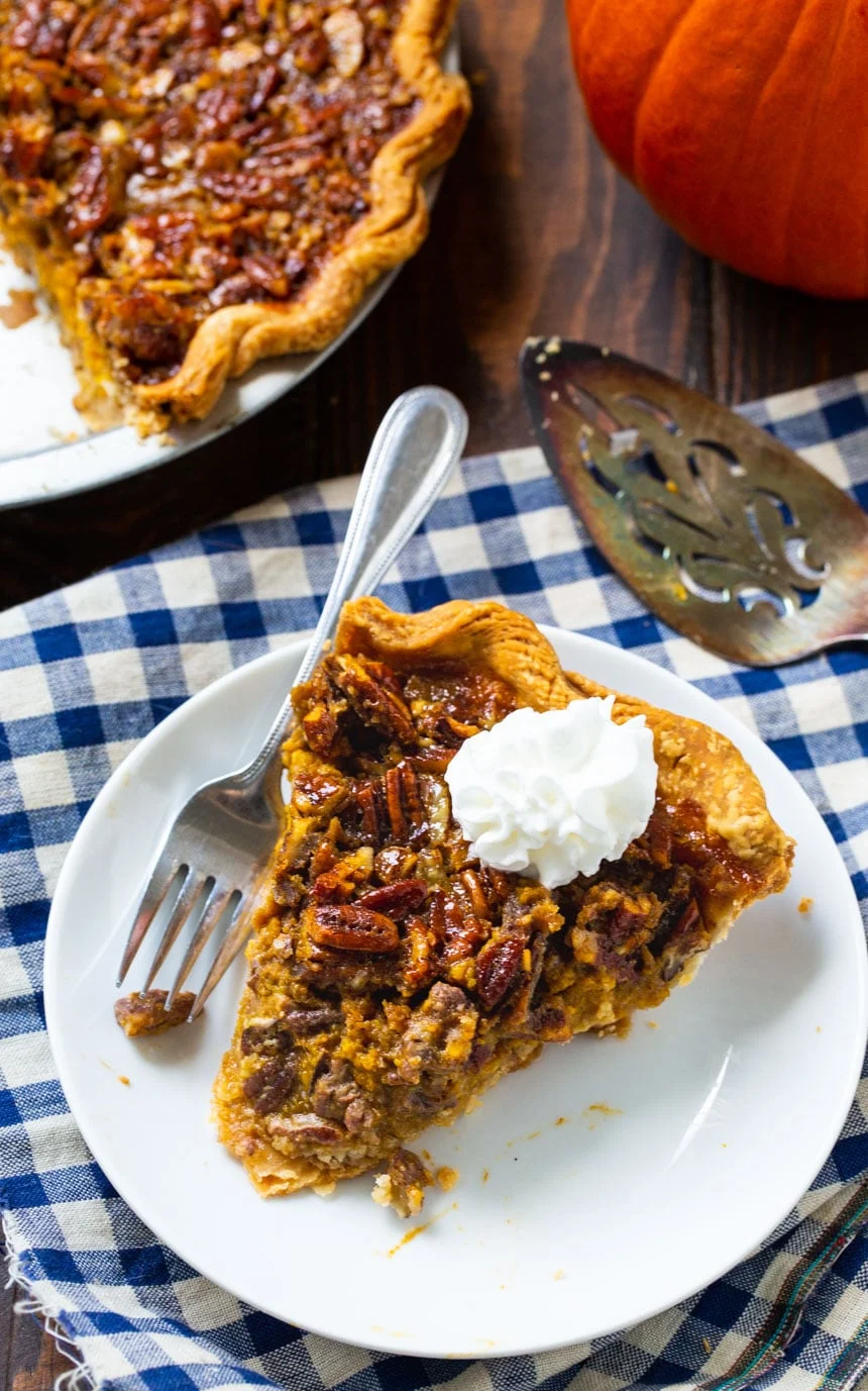 Overhead of slice of Pumpkin Pecan Pie with the rest of the pie beside it.