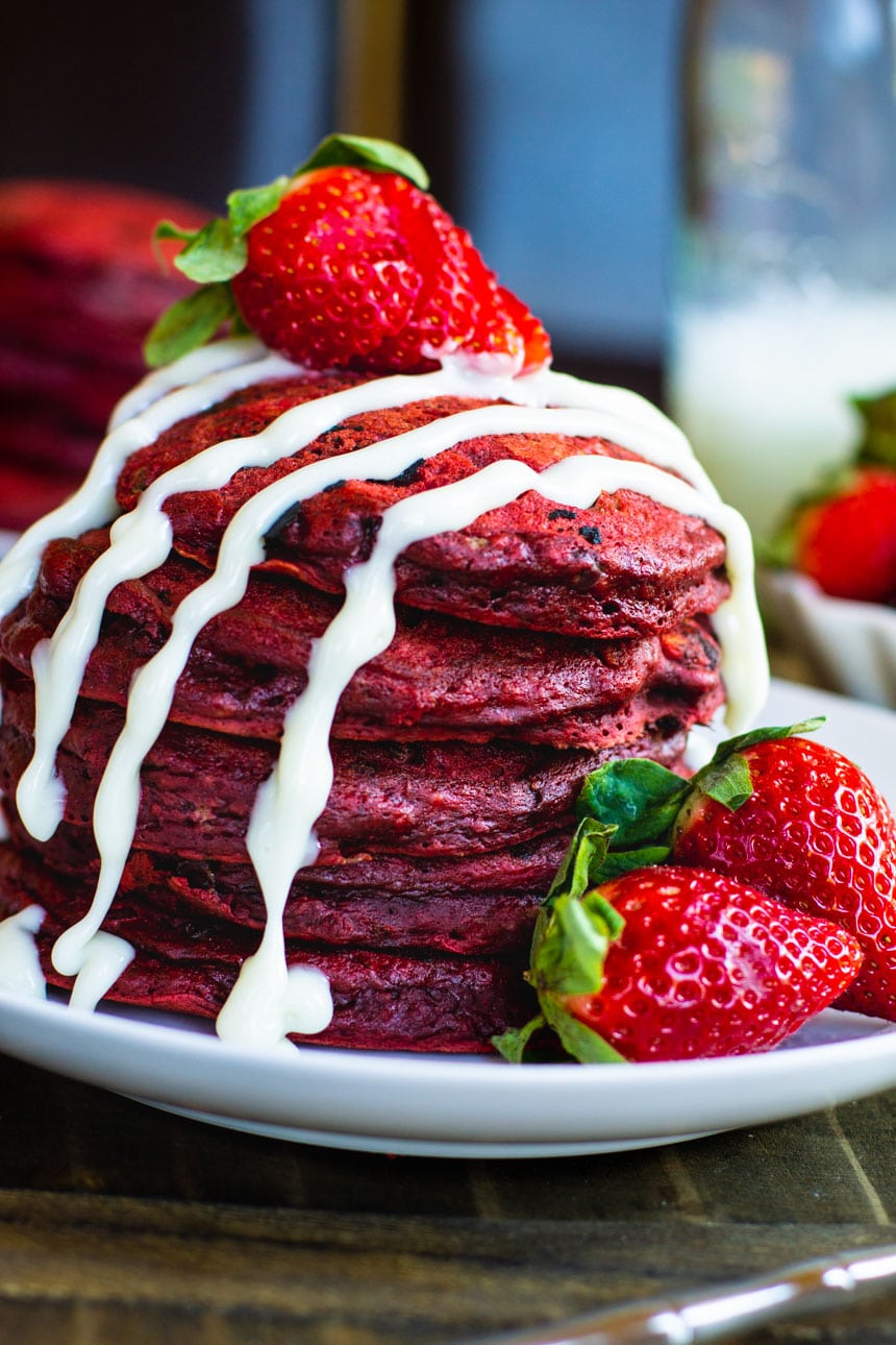 Red Velvet Pancakes with fresh strawberries and a cream cheese drizzle.