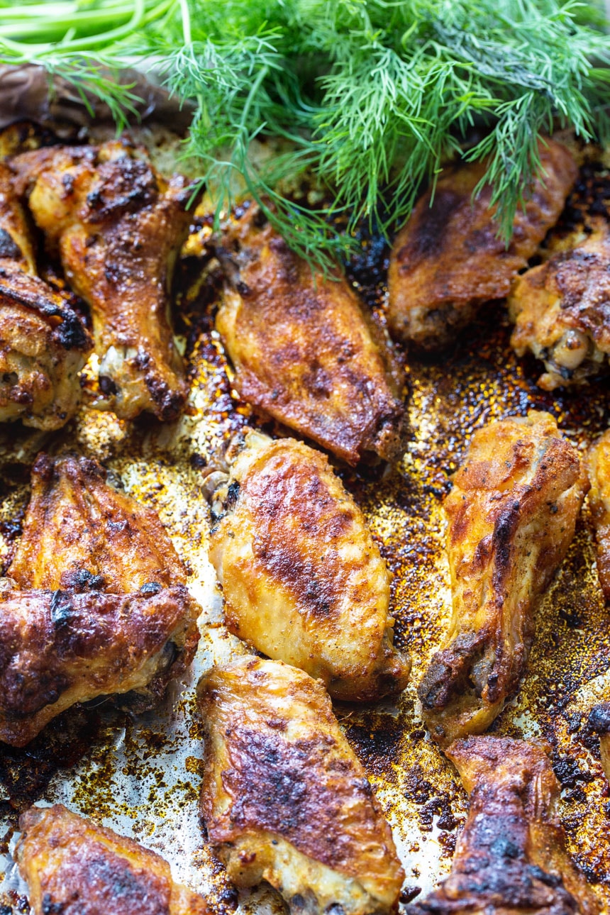 Roasted wings on baking sheet with fresh dill.