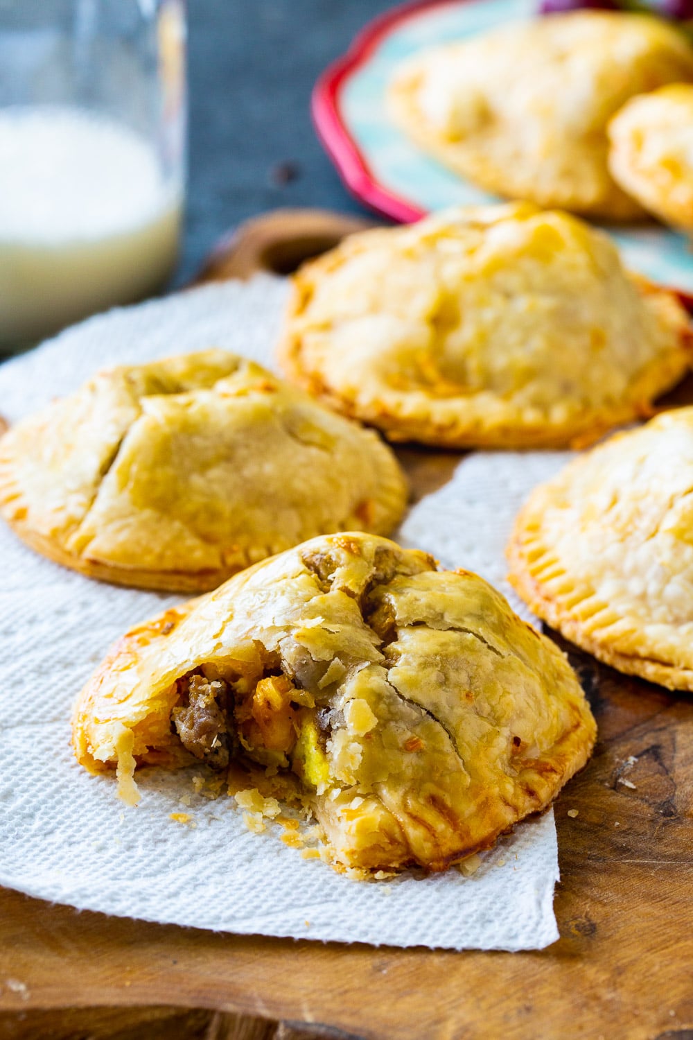 Hand Pies on a wooden board with bite out of one to show interior.