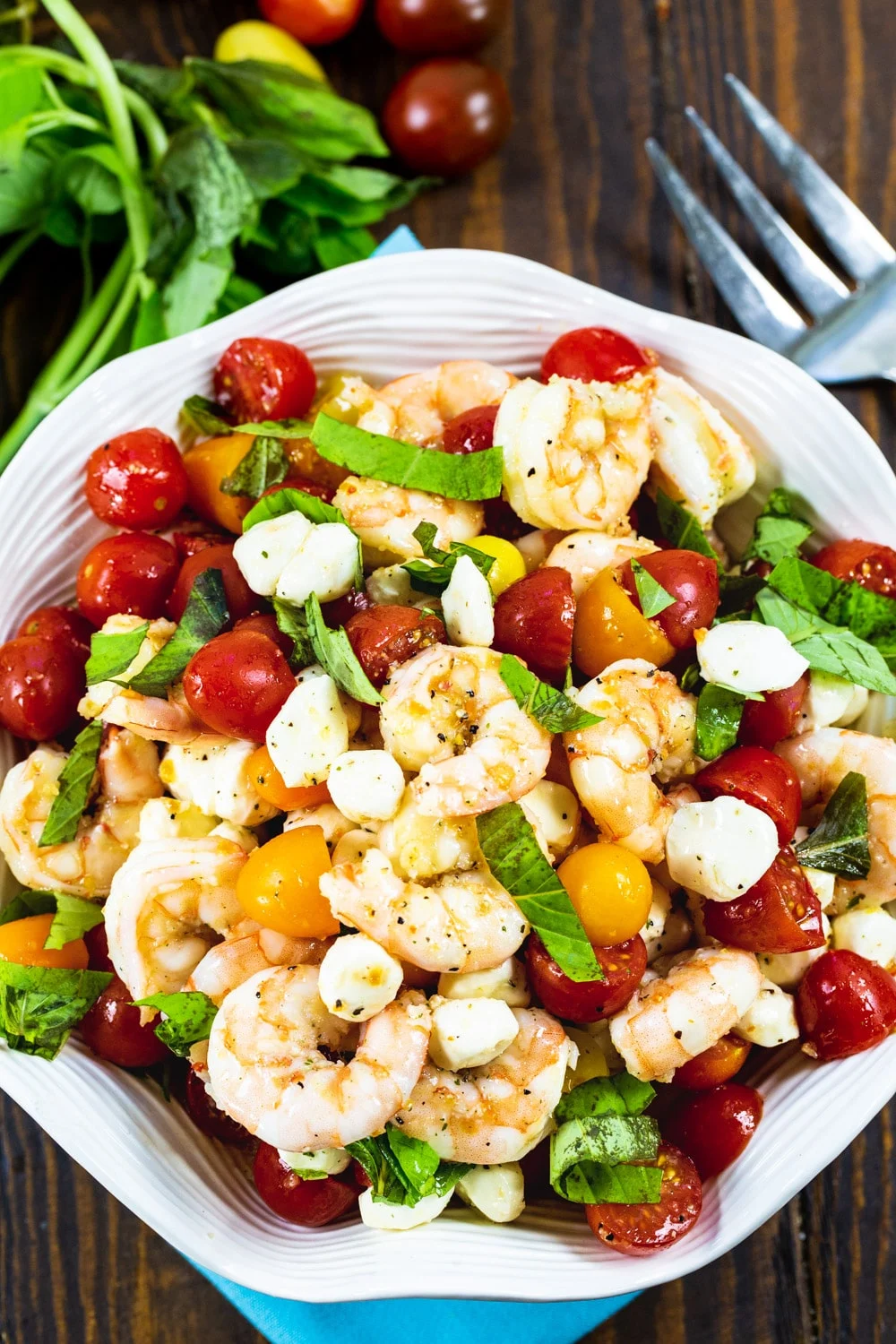 Marinated Shrimp Salad topped with fresh basil in white bowl.
