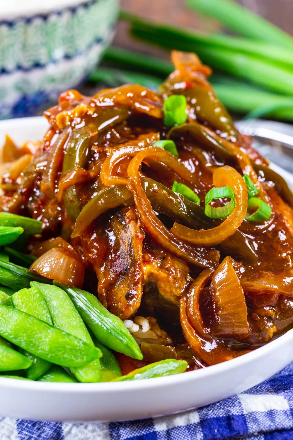 Sweet and Tangy Asian Pork Chops on a plate with sugar snap peas.