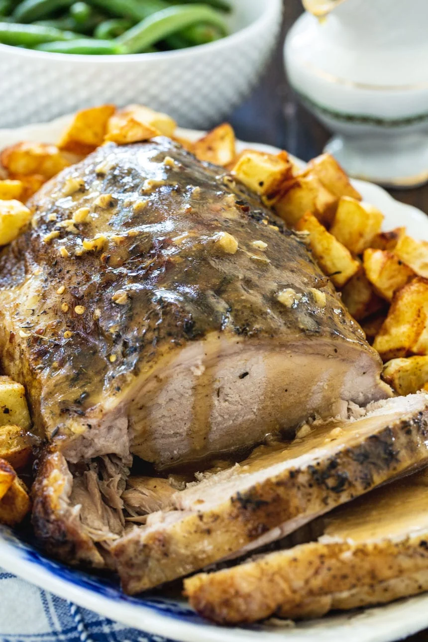 Slow Cooker Garlic Butter Pork Roast covered with gravy on serving platter.