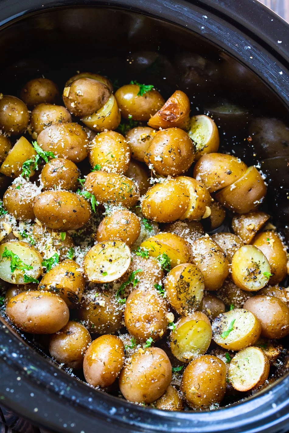 Slow Cooker Garlic Parmesan Potatoes in black crock pot.