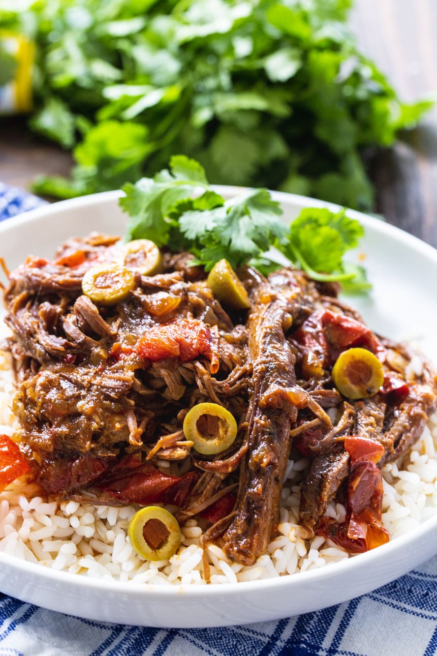 Slow Cooker Ropa Vieja served over white rice with fresh cilantro