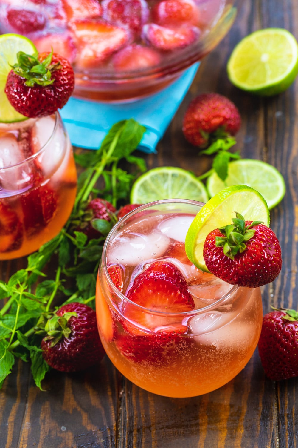 Sangria in 2 glasses with a pitcher in the background.