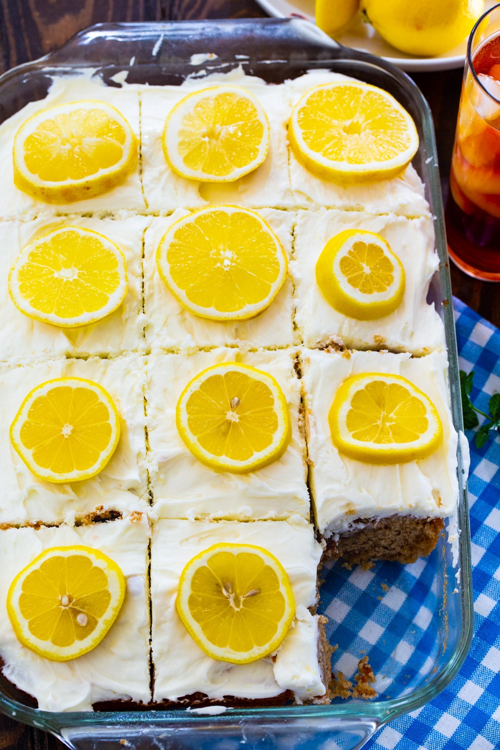 Cake topped with lemon slices in a 9x13-inch pan.