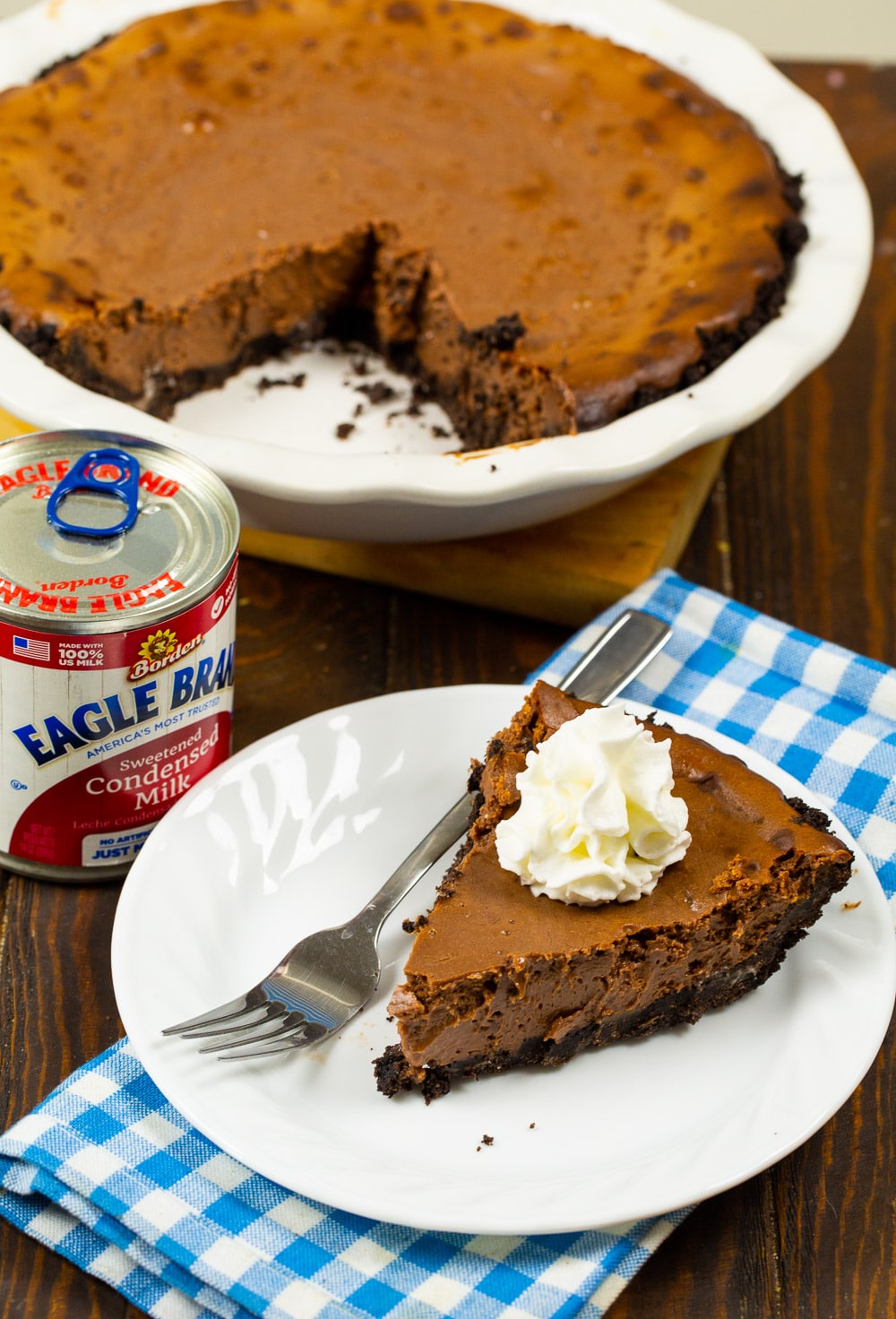 Slice of pie on a plate with rest of the pie behind it.