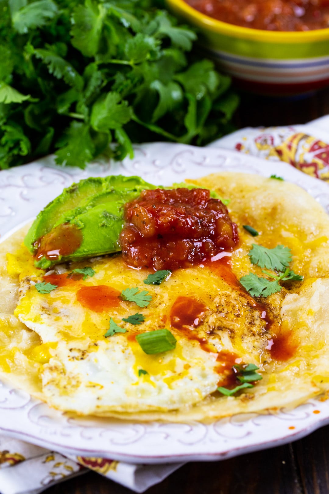 Tortilla Eggs on a plate and a bunch of cilantro.