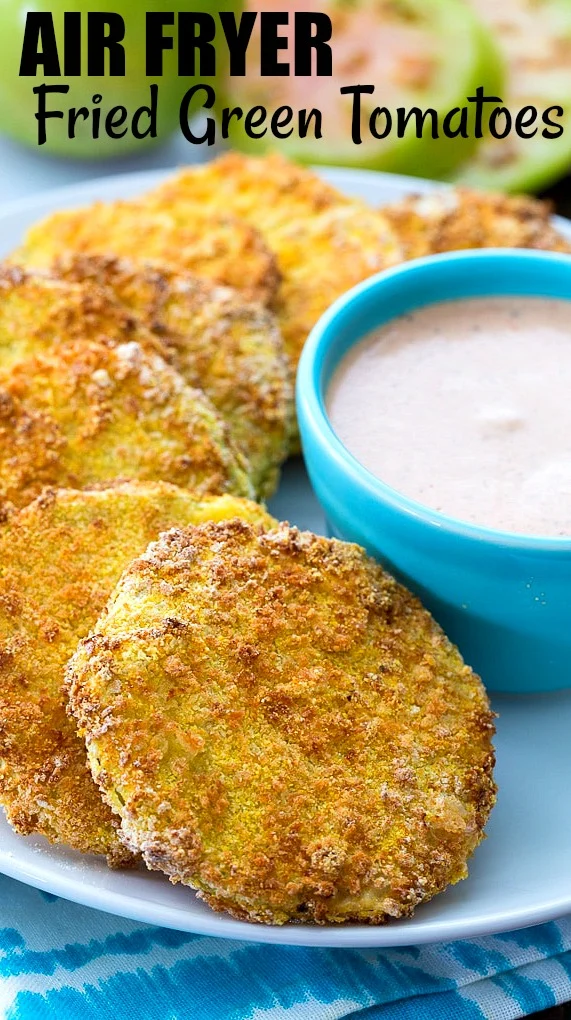 Green Tomato slices that have been fried on a plate with dipping sauce.