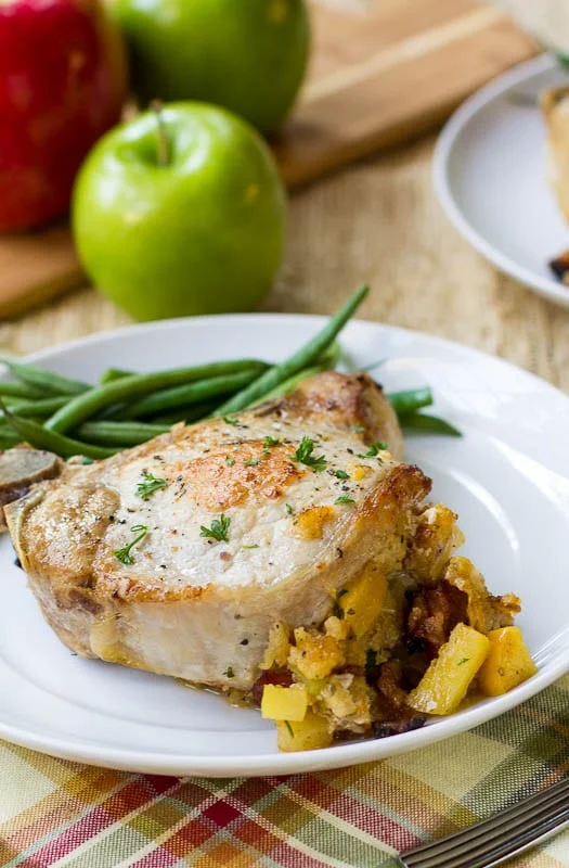 Apple-Bacon Stuffed Pork Chop on a plate with green beans.