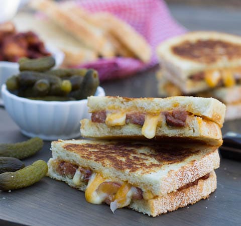 Cajun Grilled Cheese sandwich cut in half with bowl of pickles.