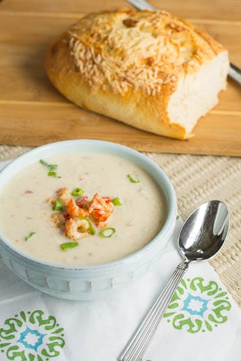 Crawfish Cauliflower Soup in a bowl with loaf of fresh bread in background.