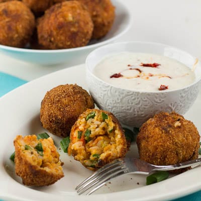 Crawfish Etouffee Balls on a plate with a bowl of dipping sauce.
