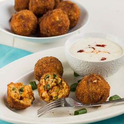 Crawfish Eouffee Balls on a plate with one cut in half to show the inside.