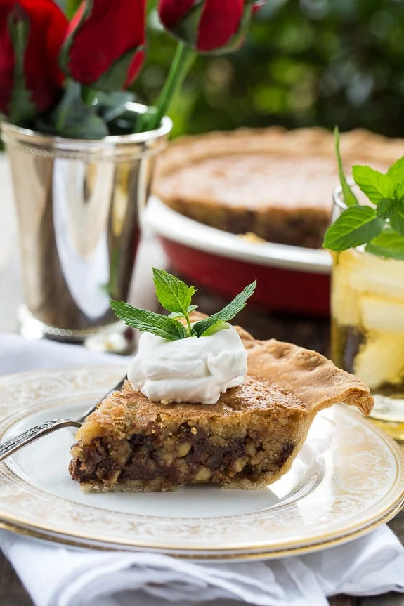 Kentucky Derby Pie has a gooey chocolate and walnut filling with a splash of bourbon. Topped with bourbon whipped cream for a fabulous southern dessert!