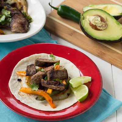 A steak fajita on a red plate.