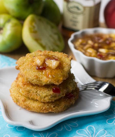 Three Fried Green Tomatoes stacked on a small white plate.