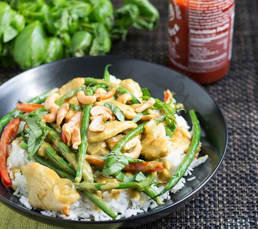 Basil, Chicken, and Green Beans in Coconut Curry Sauce over rice with fresh basil in background.