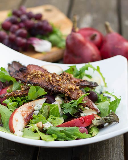 Apple-Pear Salad with Maple-Pecan Vinaigrette. Grapes and red pears in the background.