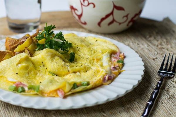 Omelet on white plate with home fries.