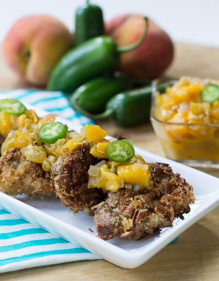 Pecan-Crusted Pork Medallions with peach chutney, and jalapenos in background.
