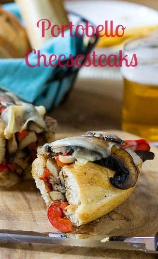 Vegetarian Portobello Cheesesteak Sandwich cut in half on a wood cutting board.