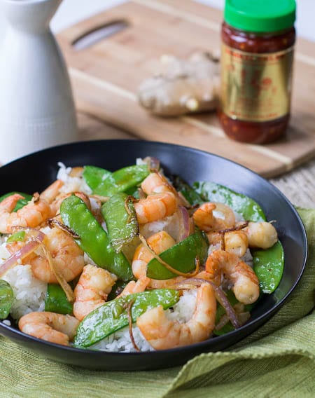 Gingered Stir Fry in bowl with chili garlic sauce in background.