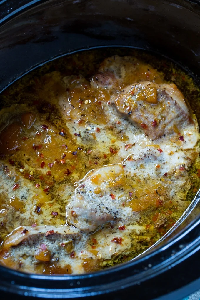 Pork chops cooked in the crockpot with spicy peach glaze.