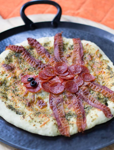 Spider Pizza on a black tray.