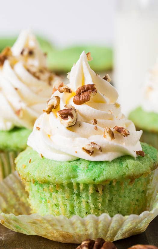 Watergate Cupcakes flavored with pistachio pudding and pineapple. Topped with a marshmallow fluff frosting.