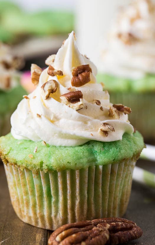 Watergate Cupcakes flavored with pistachio pudding and pineapple. Topped with marshmallow fluff frosting.
